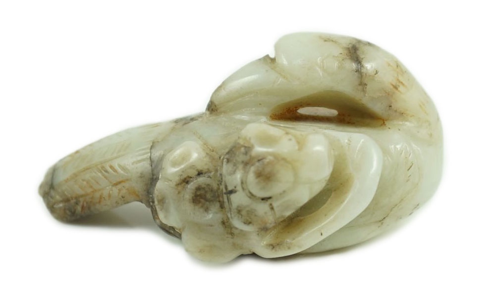 A Chinese white and black jade figure of a preening duck, Ming dynasty, 5.8 cm long